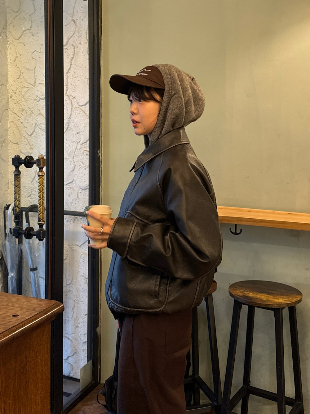 グレー系のパーカー、グレー系のブルゾン、ブラウン系のハンドバッグを着用したレディースの冬コーディネートの3枚目の写真