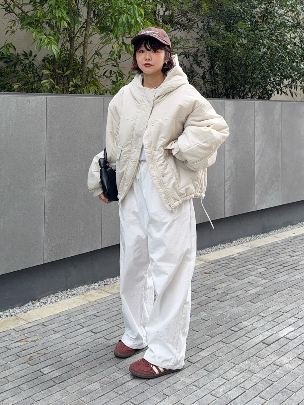 ホワイト系のブルゾン、ブラック系のハンドバッグ、ホワイト系のその他パンツを着用したレディースの秋コーディネートの5枚目の写真