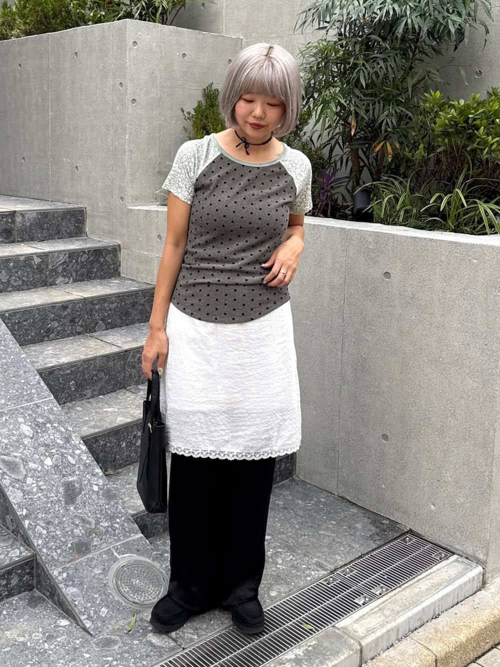 グリーン系のTシャツ/カットソー、ブラック系のその他パンツ、ホワイト系のスカートを着用したレディースの秋コーディネートの2枚目の写真
