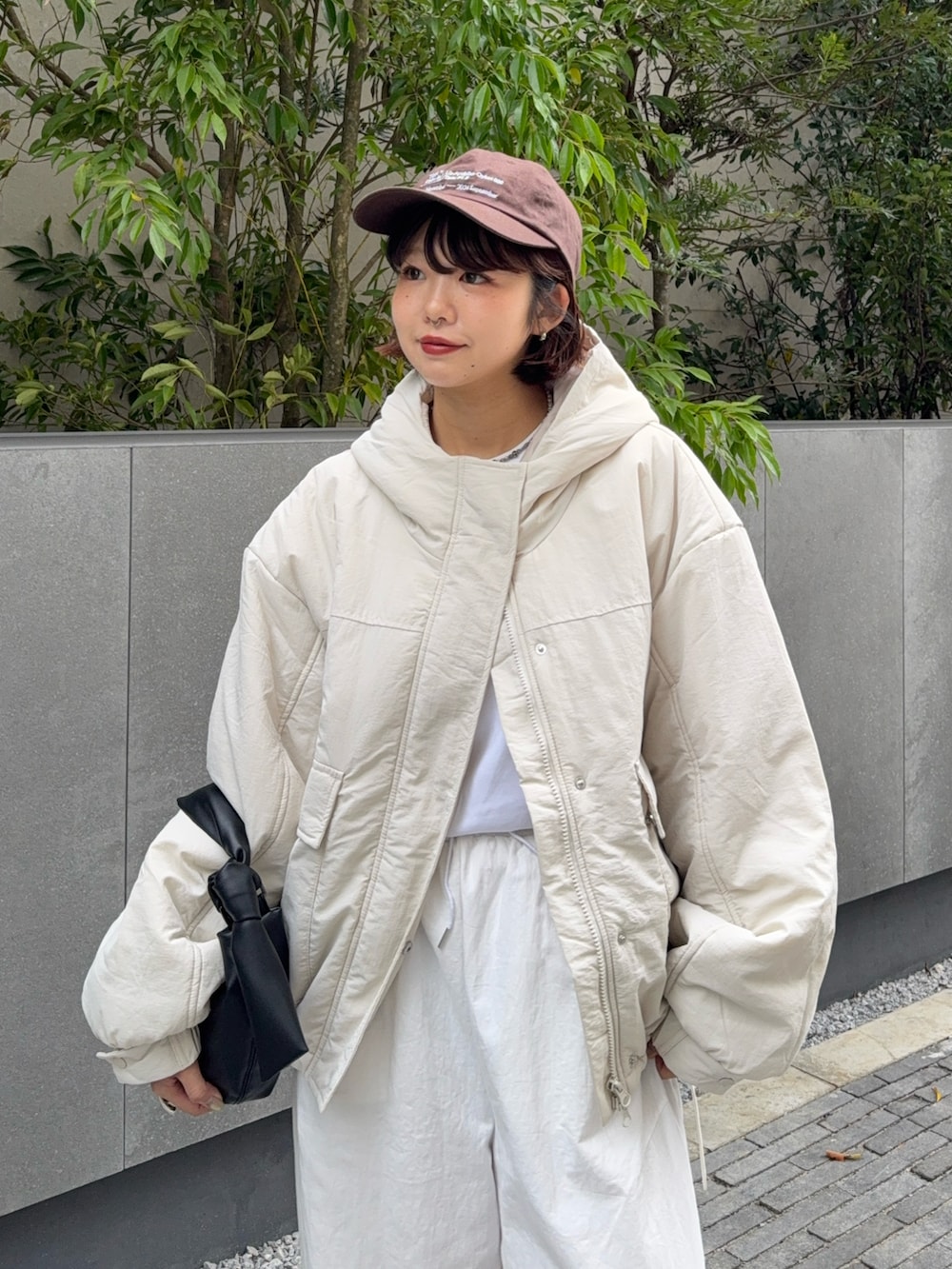 ホワイト系のブルゾン、ブラック系のハンドバッグ、ホワイト系のその他パンツを着用したレディースの秋コーディネートの3枚目の写真