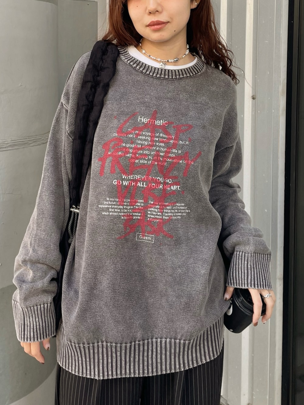 ブラック系のニット/セーター、ブラック系のショルダーバッグ、ブラック系のスラックスを着用したレディースの冬コーディネートの2枚目の写真