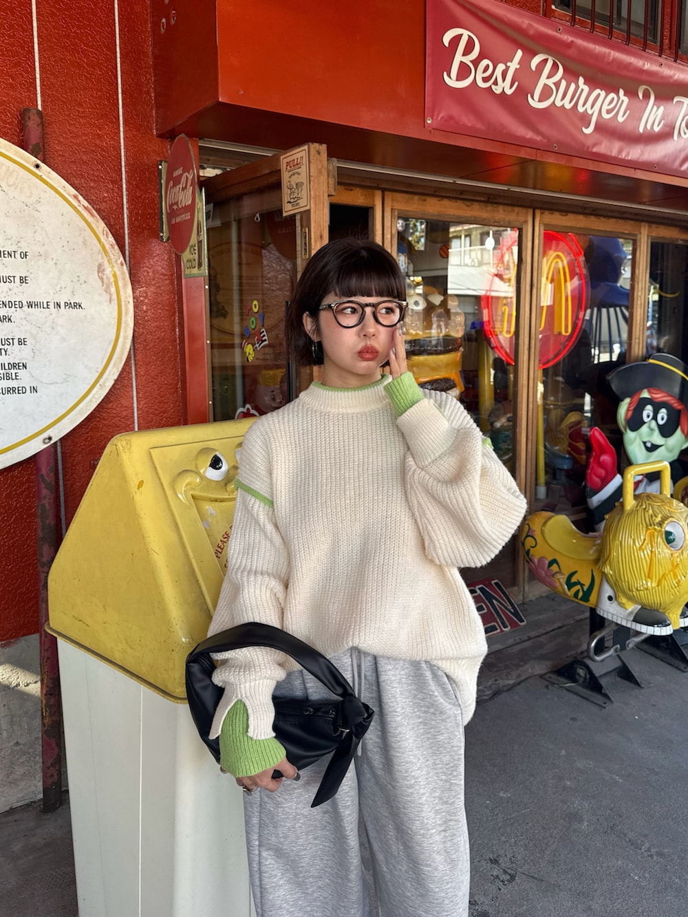 ホワイト系のニット/セーター、グレー系のその他パンツ、ブラック系のハンドバッグを着用したレディースの秋コーディネートの2枚目の写真