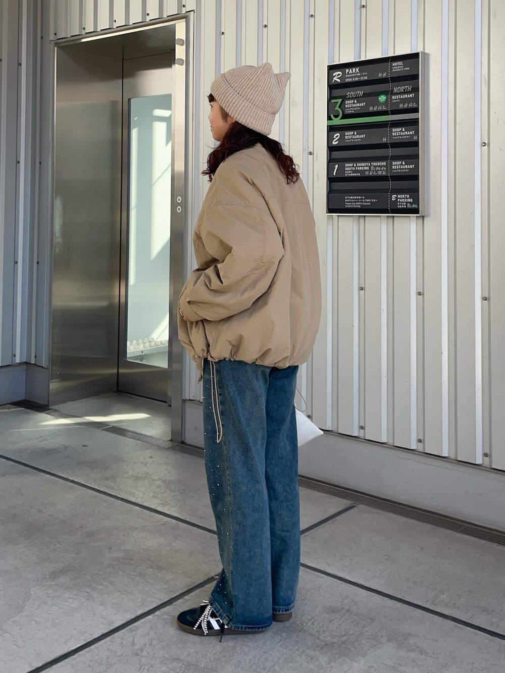 ベージュ系のブルゾン、ブルー系のデニムパンツ、シルバー系のシューズ小物/雑貨を着用したレディースの秋コーディネートの5枚目の写真