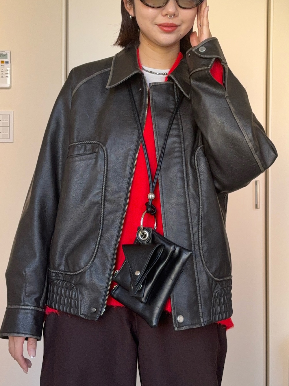レッド系のニット/セーター、グレー系のブルゾン、ブラック系のショルダーバッグを着用したレディースの冬コーディネートの2枚目の写真