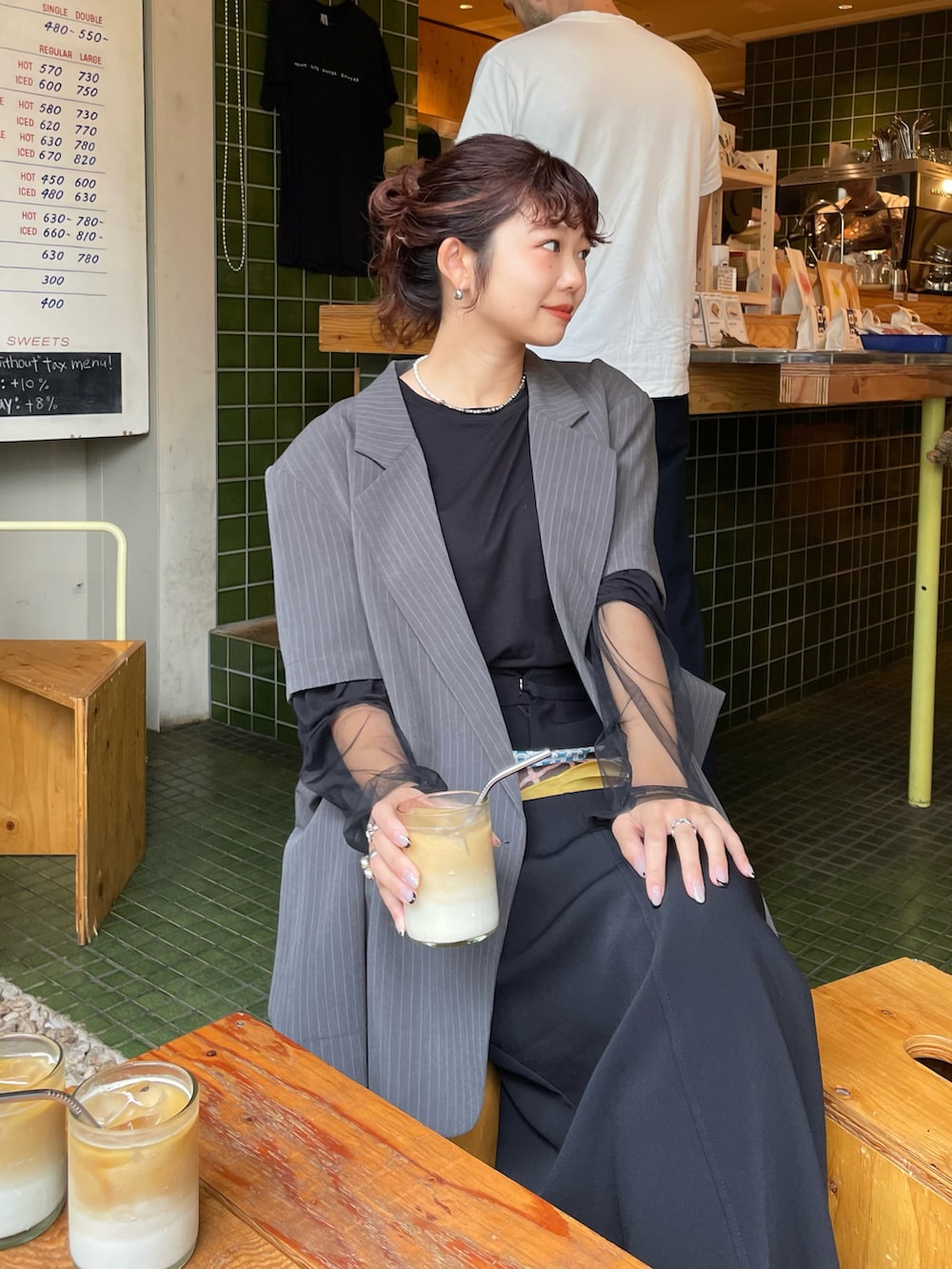 グレー系のテーラードジャケット、ブラック系のスカート、ブラック系のブーツを着用したレディースの秋コーディネートの3枚目の写真