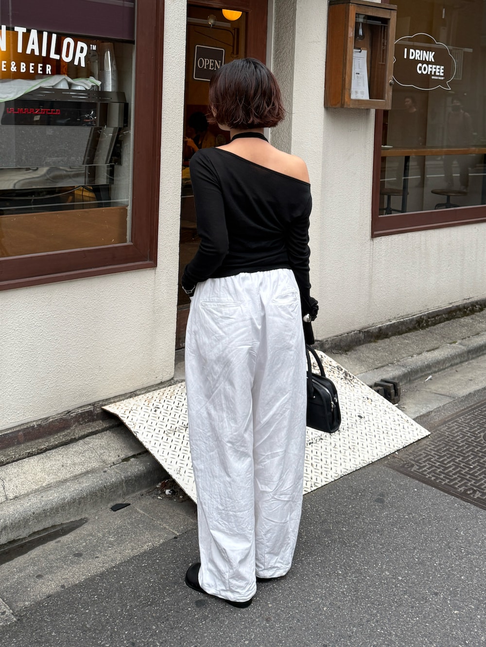 ブラック系のボストンバッグ、ブラック系のTシャツ/カットソー、ホワイト系のその他パンツを着用したレディースの秋コーディネートの5枚目の写真