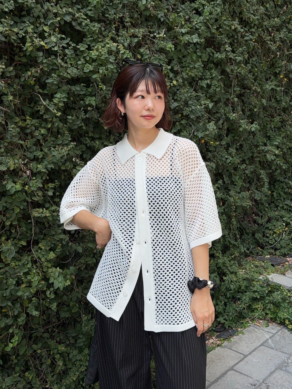 ブラック系のスラックス、ホワイト系のシャツ/ブラウス、ブラック系のショルダーバッグを着用したレディースの夏コーディネートの4枚目の写真