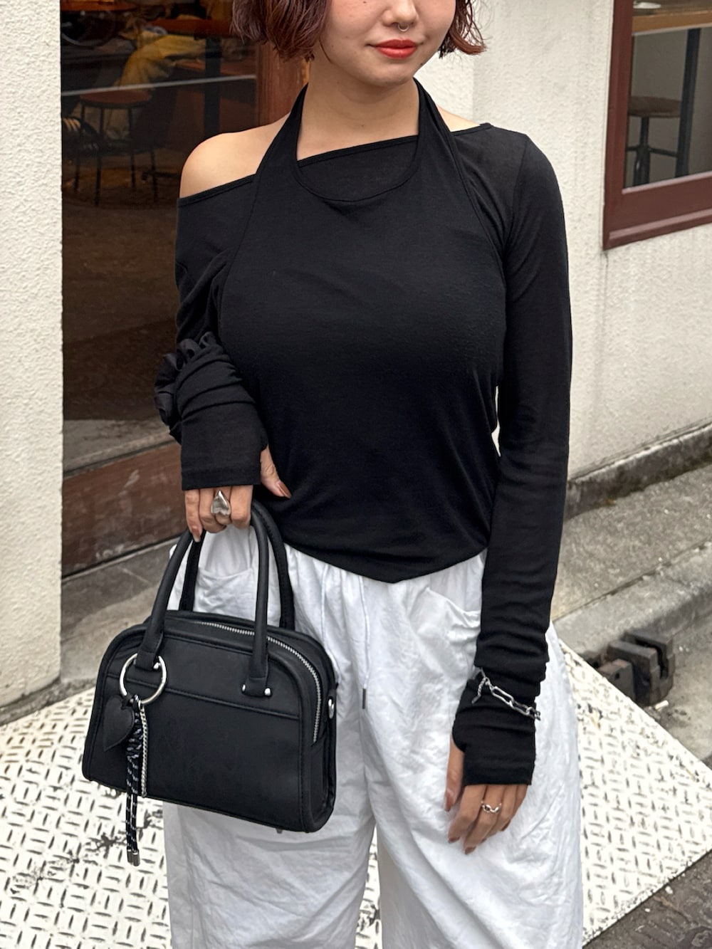 ブラック系のボストンバッグ、ブラック系のTシャツ/カットソー、ホワイト系のその他パンツを着用したレディースの秋コーディネートの3枚目の写真