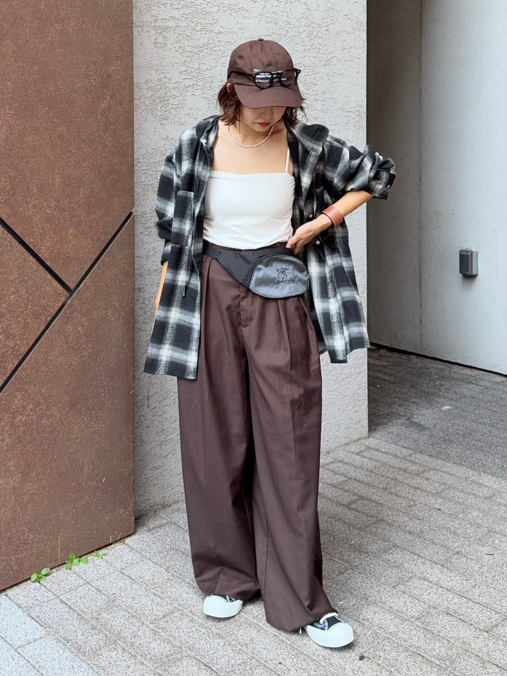 ブラック系のシャツ/ブラウス、ブラウン系のスラックス、ブラック系のスニーカーを着用したレディースの夏コーディネートの5枚目の写真