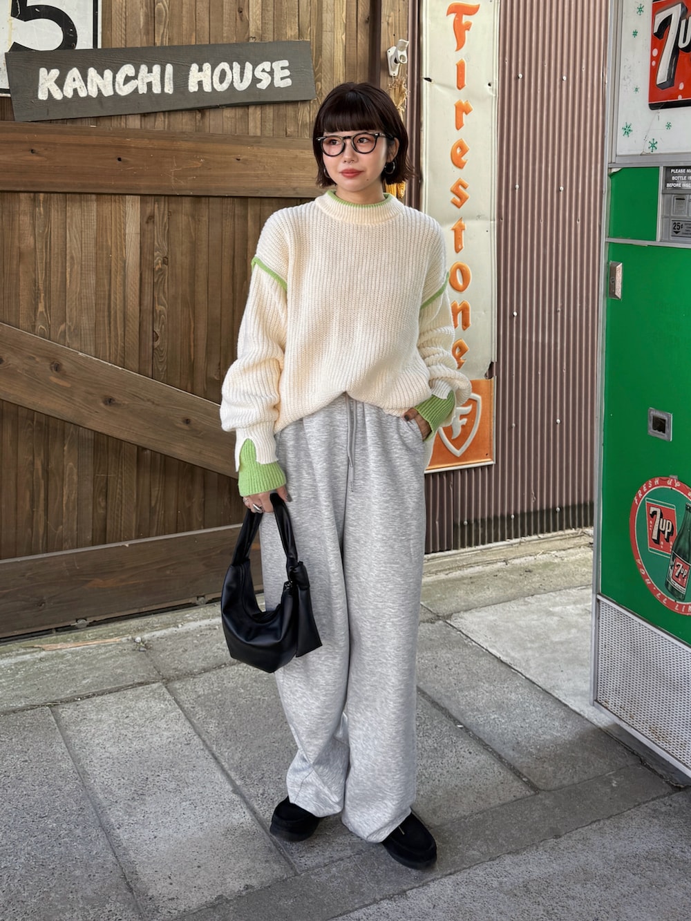 ホワイト系のニット/セーター、グレー系のその他パンツ、ブラック系のハンドバッグを着用したレディースの秋コーディネートの4枚目の写真