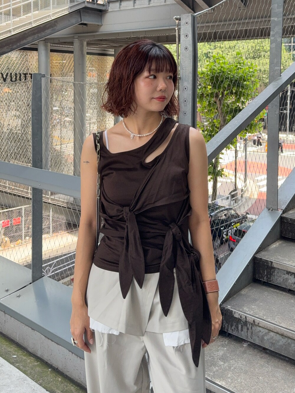 ブラウン系のTシャツ/カットソー、ベージュ系のスラックス、ホワイト系のスニーカーを着用したレディースの夏コーディネートの3枚目の写真