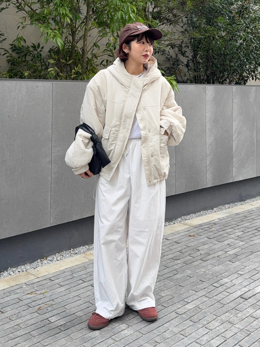 ホワイト系のブルゾン、ブラック系のハンドバッグ、ホワイト系のその他パンツを着用したレディースの秋コーディネートの4枚目の写真