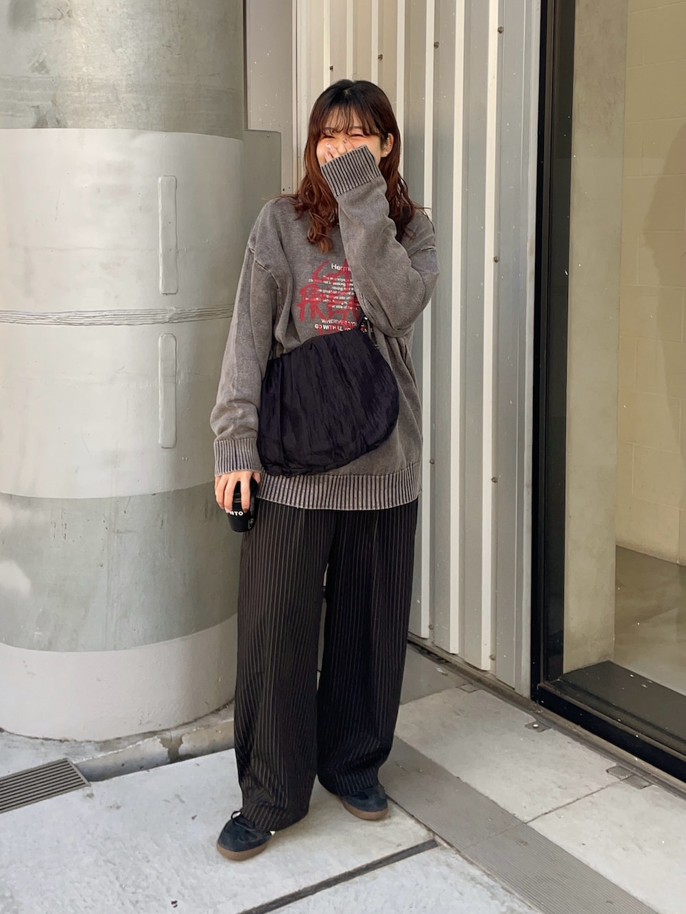 ブラック系のニット/セーター、ブラック系のショルダーバッグ、ブラック系のスラックスを着用したレディースの冬コーディネートの3枚目の写真