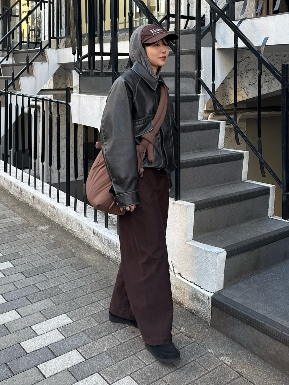 グレー系のパーカー、グレー系のブルゾン、ブラウン系のハンドバッグを着用したレディースの冬コーディネートの2枚目の写真