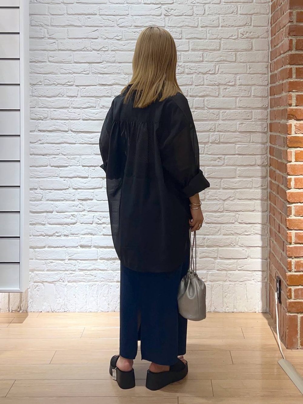 ブルー系のスカート、ブラック系のサンダル、ホワイト系のTシャツ/カットソーを着用したレディースの夏コーディネートの3枚目の写真
