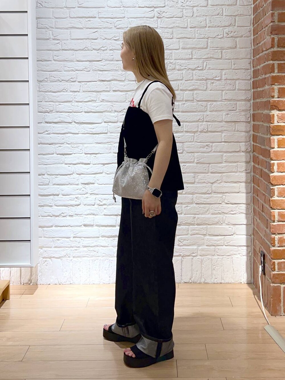 ブラック系のサンダル、シルバー系のショルダーバッグ、グレー系のデニムパンツを着用したレディースの秋コーディネートの2枚目の写真