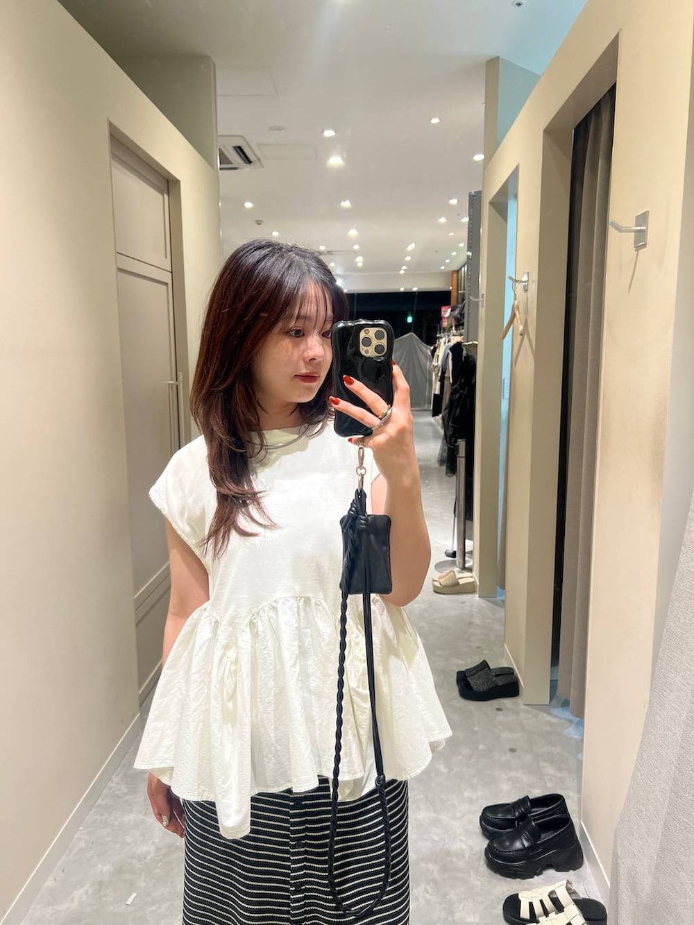 ホワイト系のTシャツ/カットソー、ブラック系のサンダル、ブラック系のスカートを着用したレディースの夏コーディネートの3枚目の写真