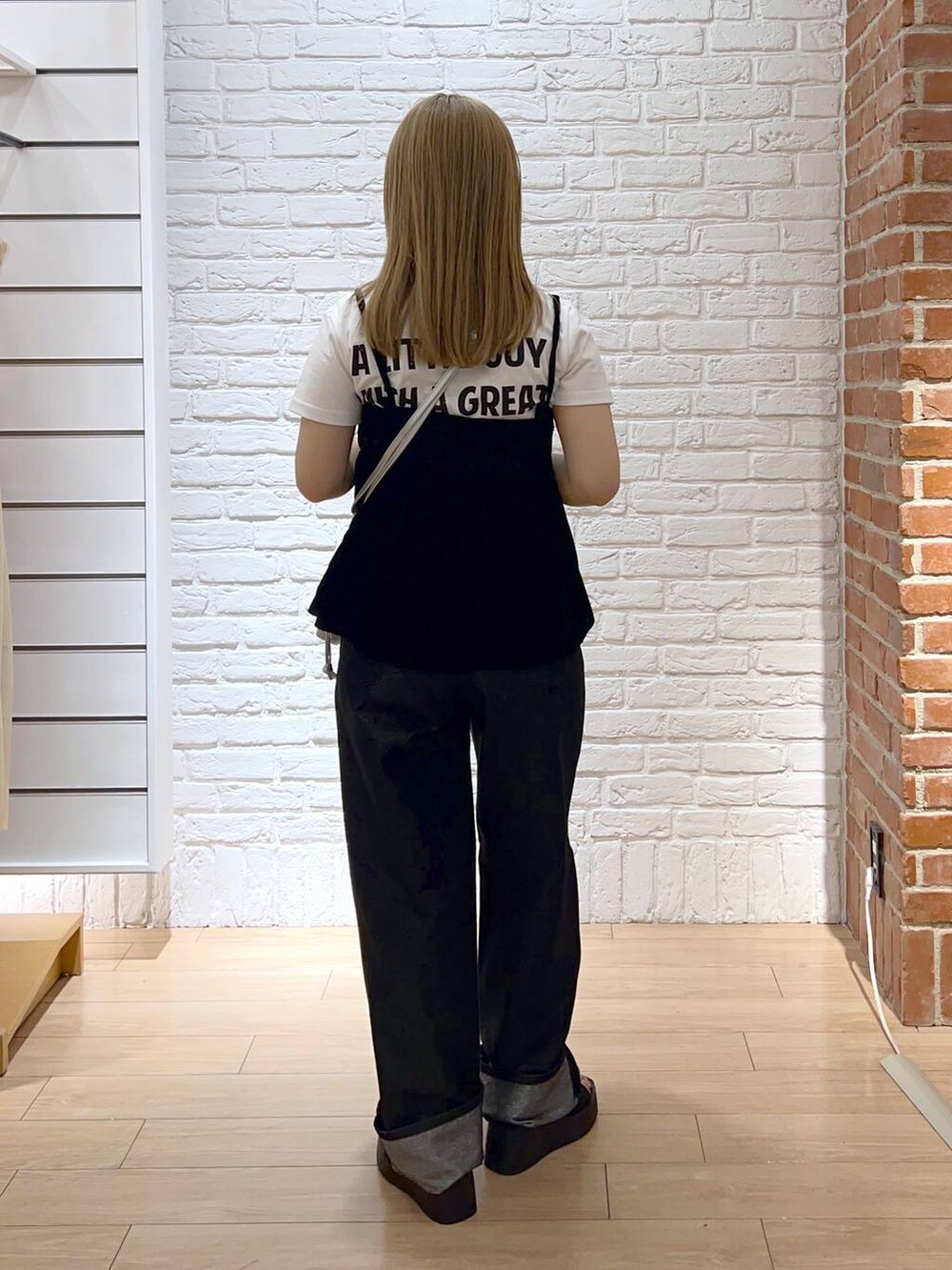 ブラック系のサンダル、シルバー系のショルダーバッグ、グレー系のデニムパンツを着用したレディースの秋コーディネートの3枚目の写真