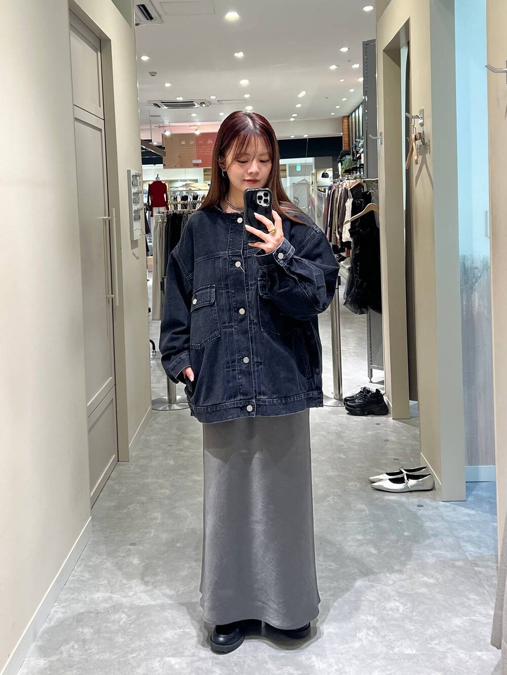 グレー系のスカート、ブラック系のデニムジャケットを着用したレディースの秋コーディネートの2枚目の写真