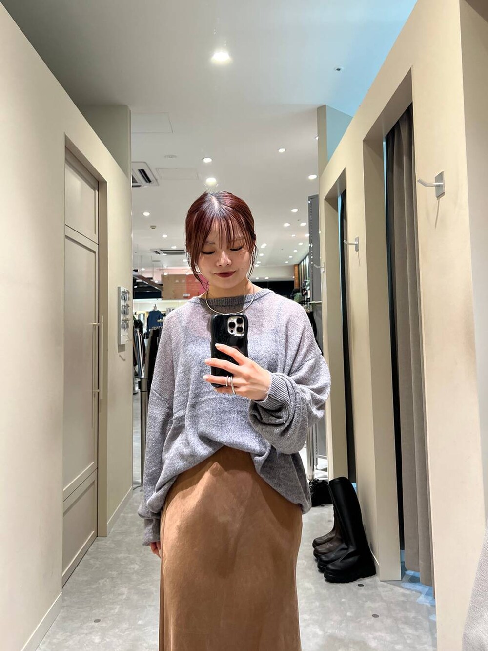 ブラウン系のスカート、グレー系のニット/セーターを着用したレディースの秋コーディネートの2枚目の写真