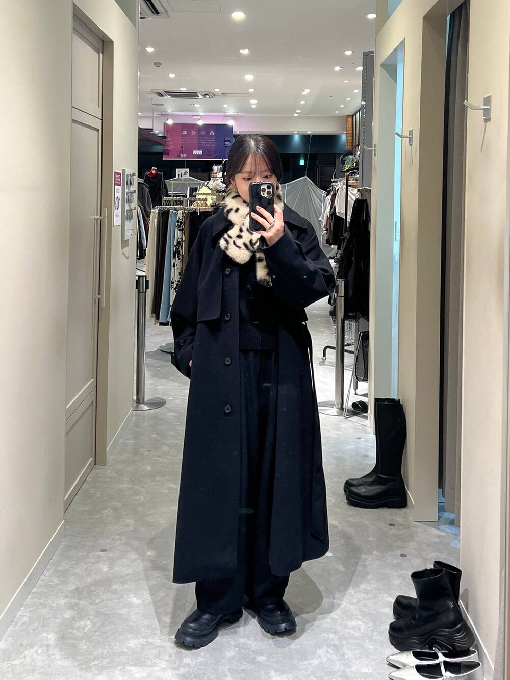 ブラック系のステンカラーコート、ブラック系のTシャツ/カットソー、その他のネックウォーマー/スヌードを着用したレディースの秋コーディネートの2枚目の写真