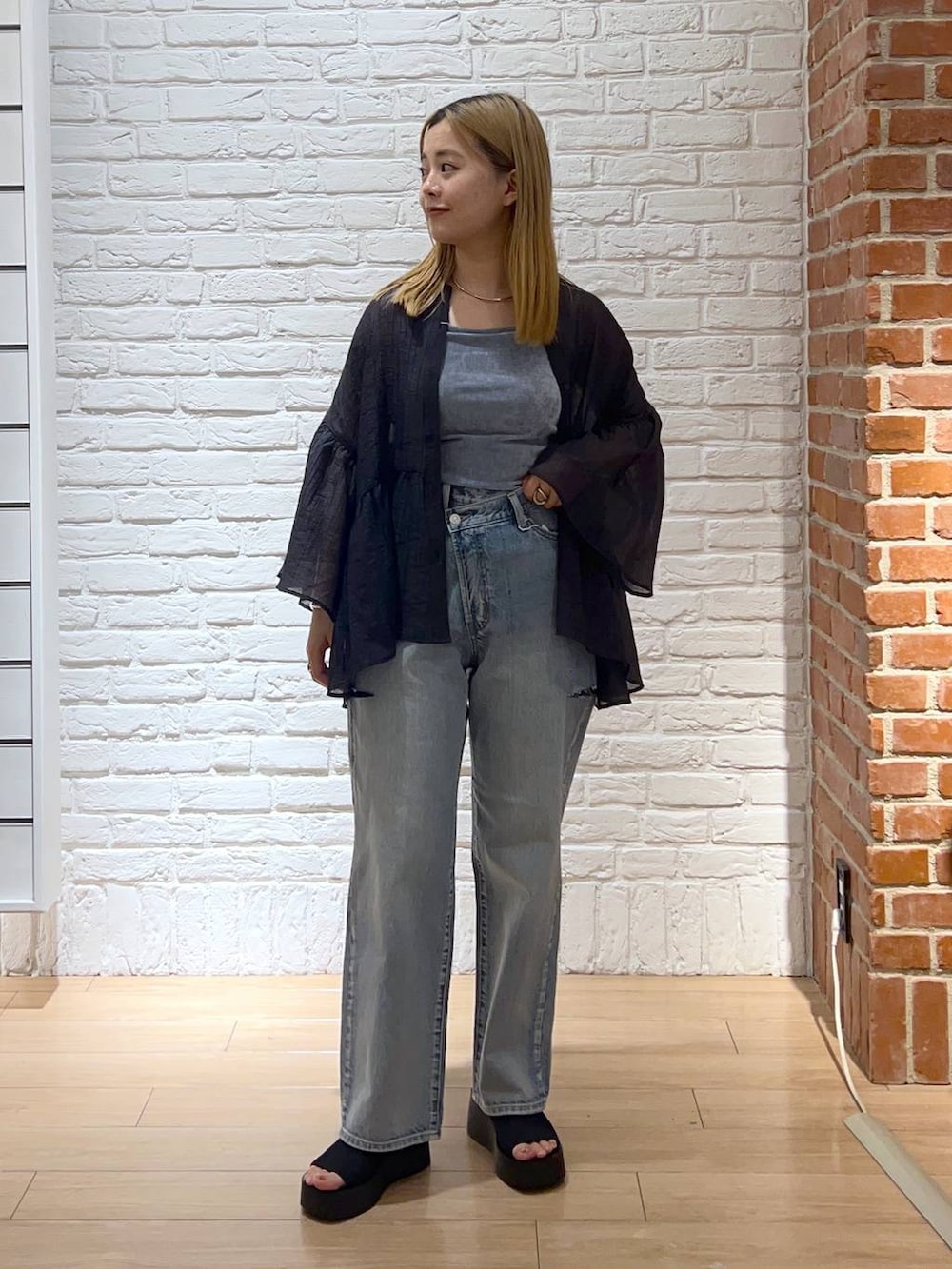 ブラック系のサンダル、ブルー系のデニムパンツ、グレー系のシャツ/ブラウスを着用したレディースの夏コーディネートの2枚目の写真