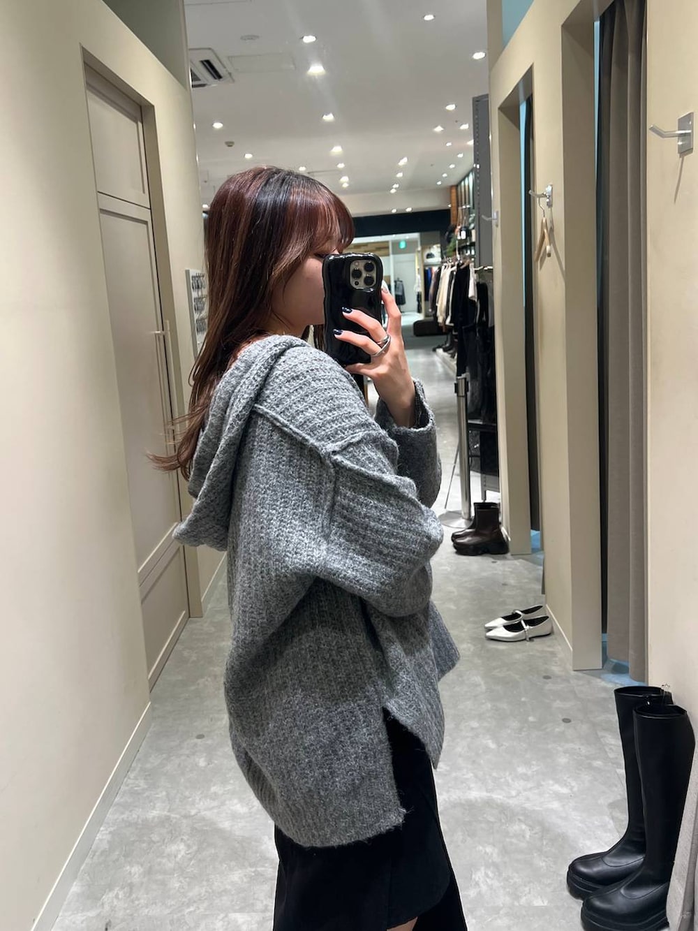 グレー系のニット/セーター、ブラック系のスカートを着用したレディースの秋コーディネートの4枚目の写真