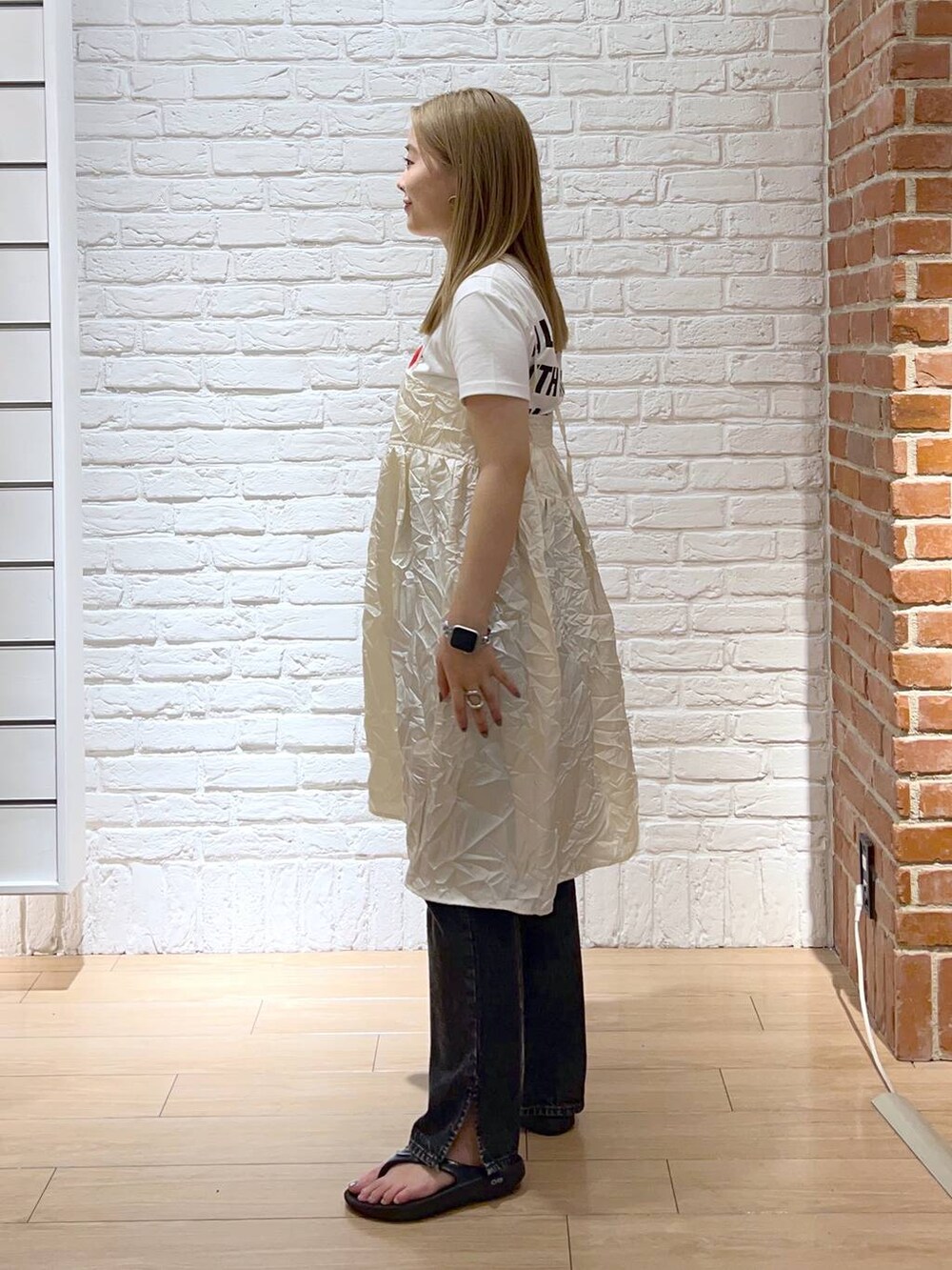 ブラック系のデニムパンツ、ホワイト系のTシャツ/カットソー、ホワイト系のキャミソールを着用したレディースの夏コーディネートの2枚目の写真