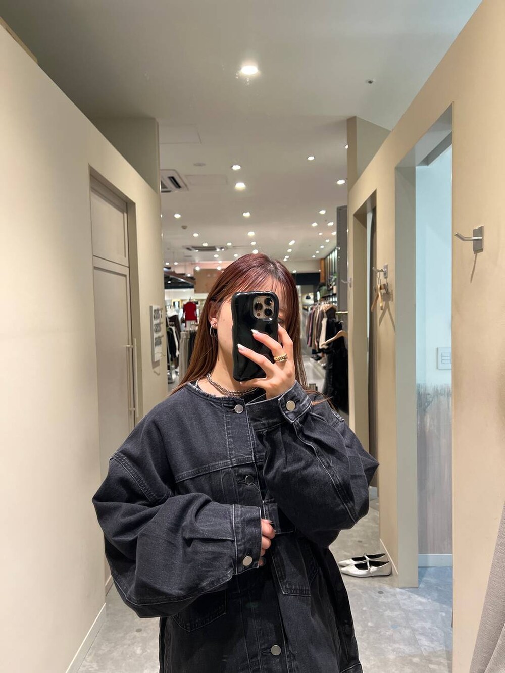 グレー系のスカート、ブラック系のデニムジャケットを着用したレディースの秋コーディネートの3枚目の写真