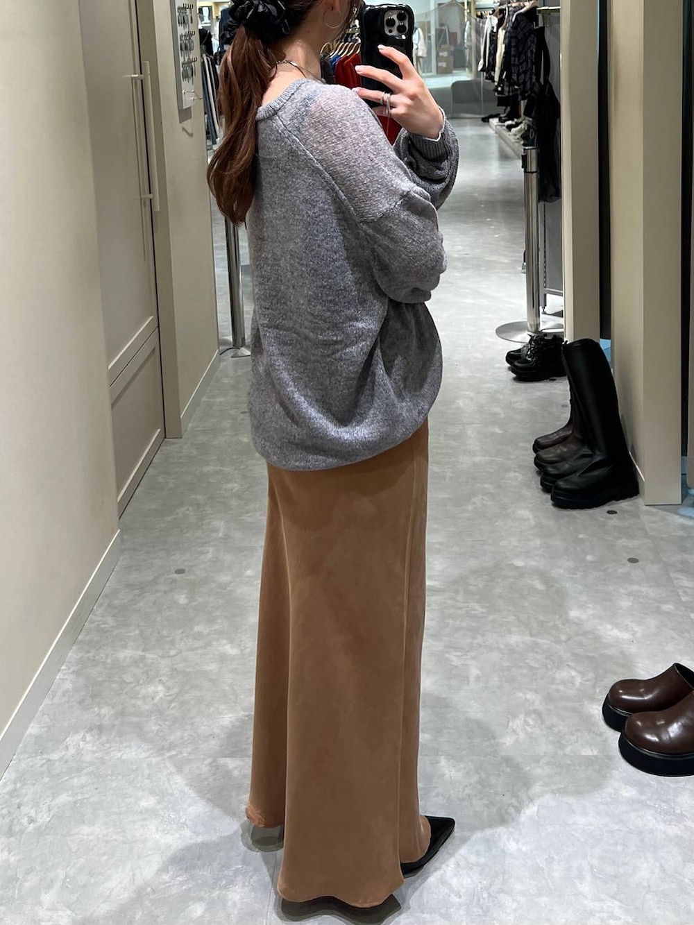 ブラウン系のスカート、グレー系のニット/セーターを着用したレディースの秋コーディネートの3枚目の写真