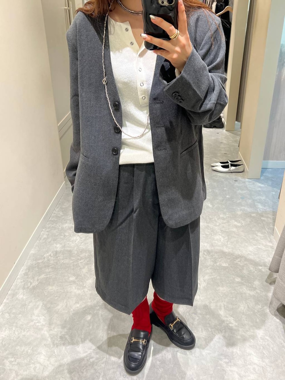 グレー系のテーラードジャケット、グレー系のその他パンツ、ホワイト系のニット/セーターを着用したレディースの秋コーディネートの2枚目の写真