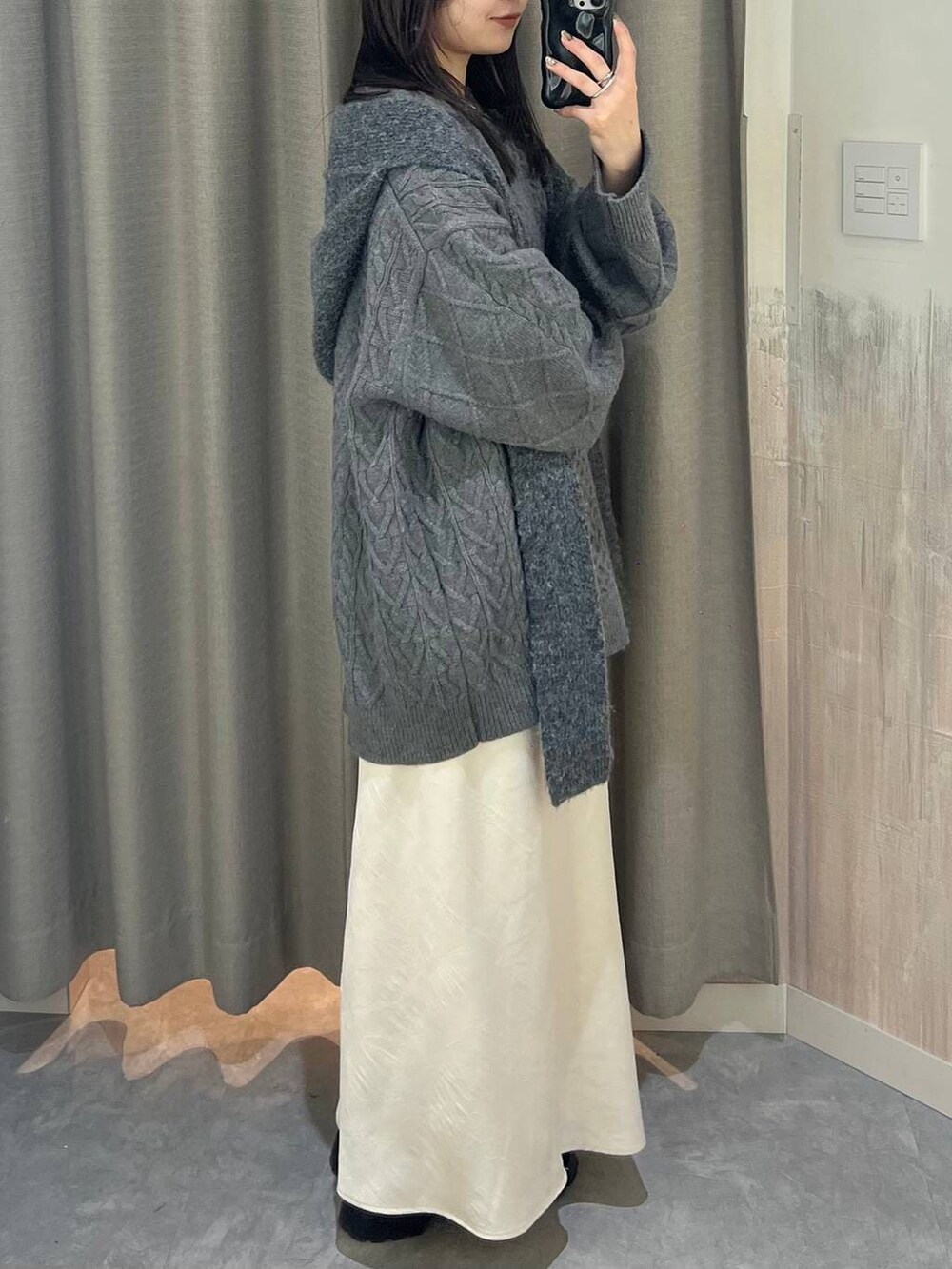 ホワイト系のスカート、グレー系のニット/セーター、グレー系のマフラーを着用したレディースの冬コーディネートの2枚目の写真