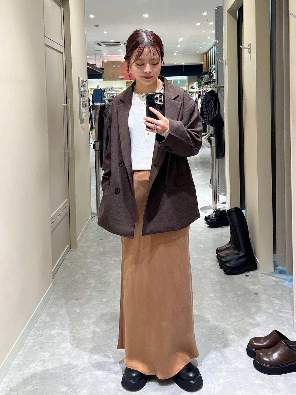 ブラウン系のテーラードジャケット、ブラック系のサンダル、ブラウン系のスカートを着用したレディースの秋コーディネートの2枚目の写真