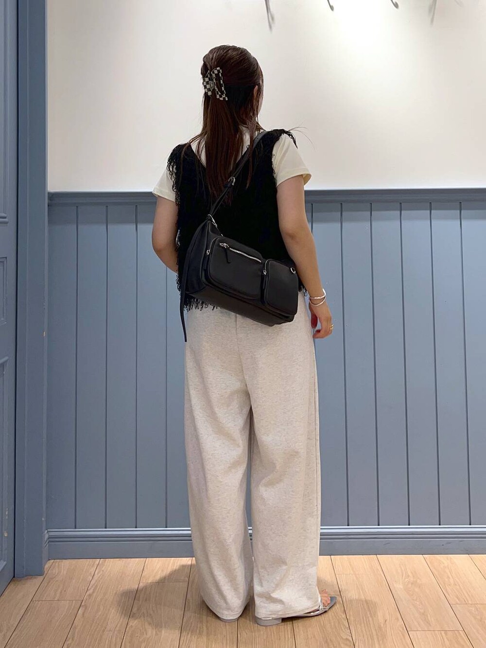 シルバー系のサンダル、グレー系のデニムパンツ、ブラック系のショルダーバッグを着用したレディースの夏コーディネートの4枚目の写真