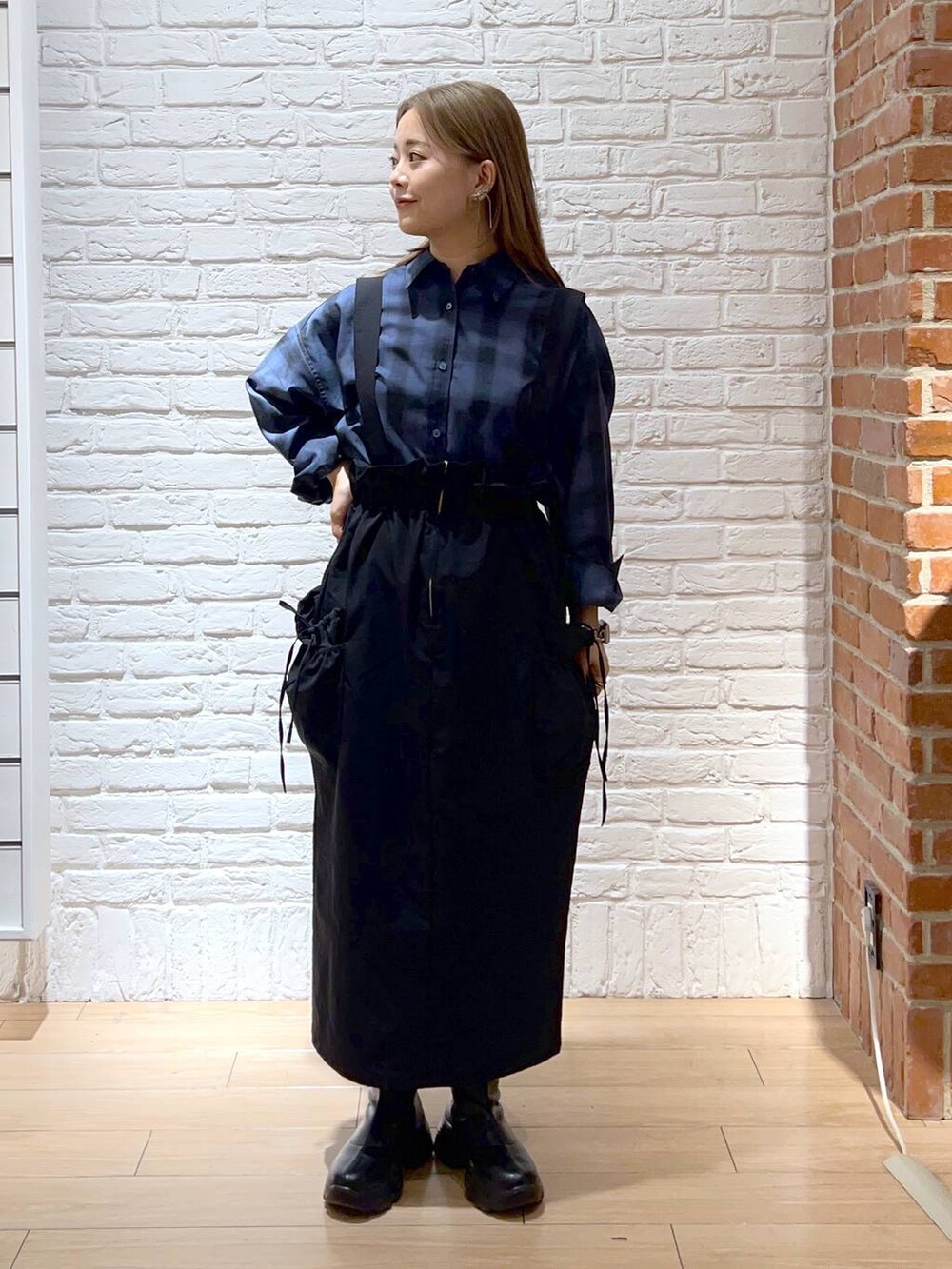 ブラック系のブーツ、ブルー系のシャツ/ブラウス、ブラック系のスカートを着用したレディースの秋コーディネートの2枚目の写真