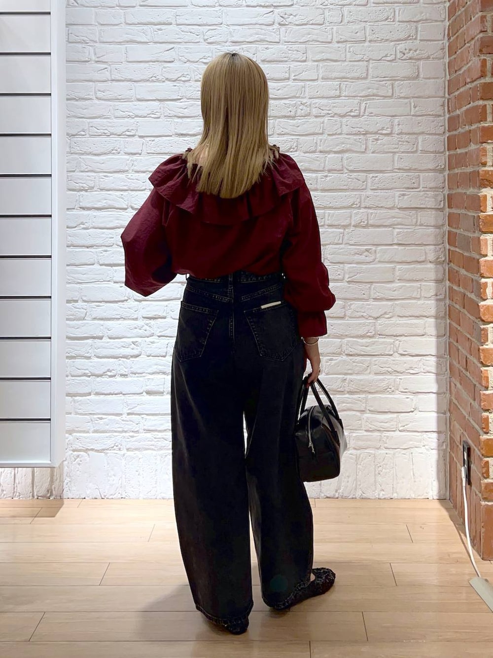 レッド系のシャツ/ブラウス、ブラック系のデニムパンツ、ブラック系のバレエシューズを着用したレディースの秋コーディネートの3枚目の写真