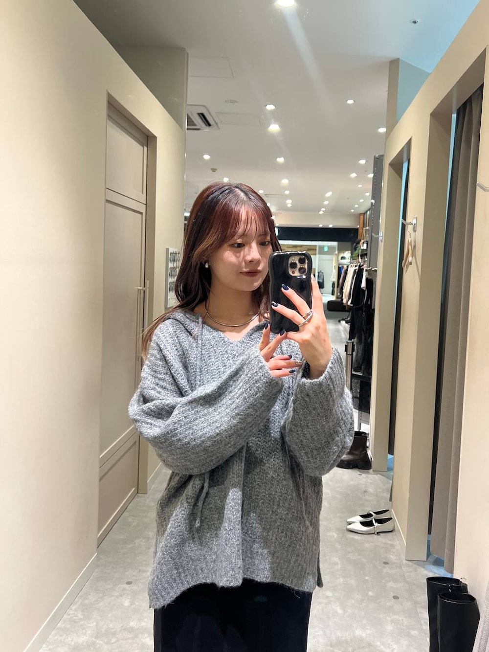 グレー系のニット/セーター、ブラック系のスカートを着用したレディースの秋コーディネートの2枚目の写真