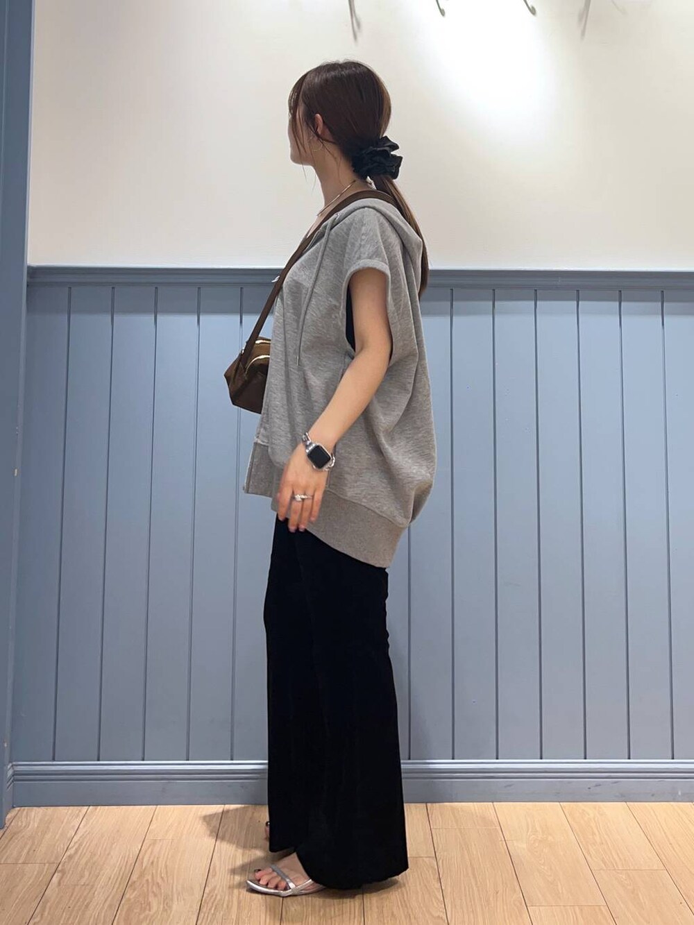 シルバー系のサンダル、グレー系のTシャツ/カットソー、ブラウン系のショルダーバッグを着用したレディースの夏コーディネートの2枚目の写真