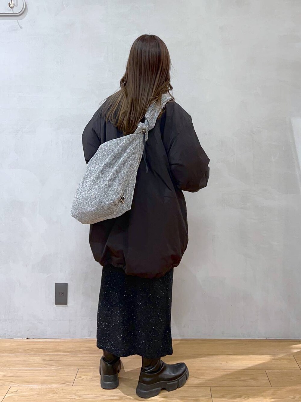 ブラック系のダウンジャケット/コート、シルバー系のショルダーバッグ、ブラック系のブーツを着用したレディースの秋コーディネートの5枚目の写真