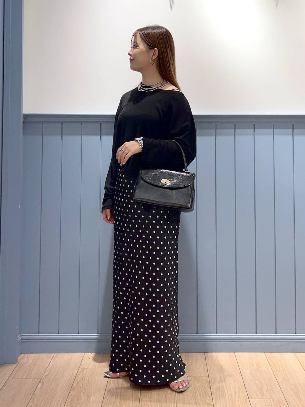 シルバー系のサンダル、ブラック系のスカート、ブラック系のTシャツ/カットソーを着用したレディースの秋コーディネートの3枚目の写真