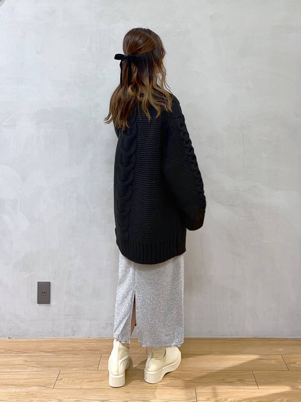 ホワイト系のブーツ、グレー系のスカート、ブラック系のショルダーバッグを着用したレディースの秋コーディネートの5枚目の写真