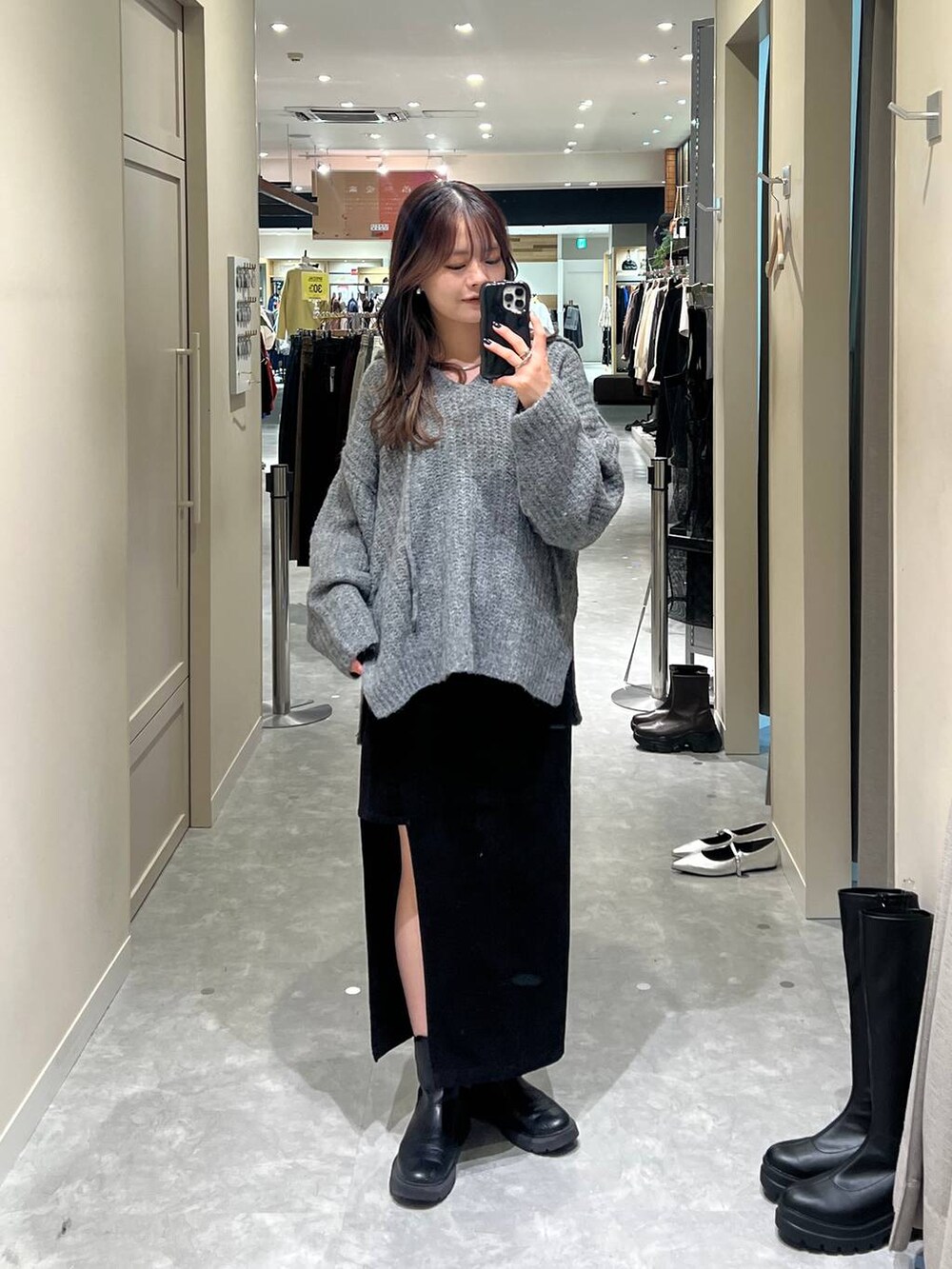 グレー系のニット/セーター、ブラック系のスカートを着用したレディースの秋コーディネートの3枚目の写真