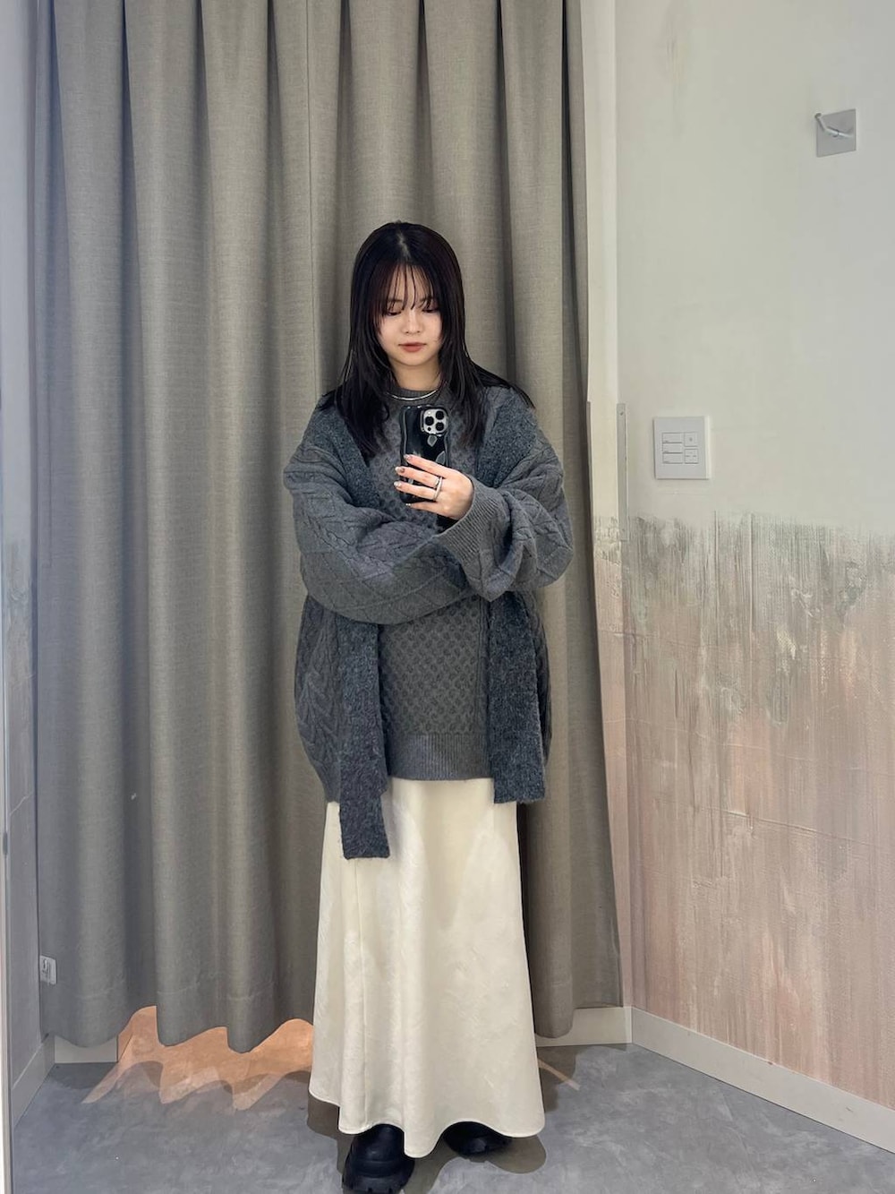 ホワイト系のスカート、グレー系のニット/セーター、グレー系のマフラーを着用したレディースの冬コーディネートの3枚目の写真
