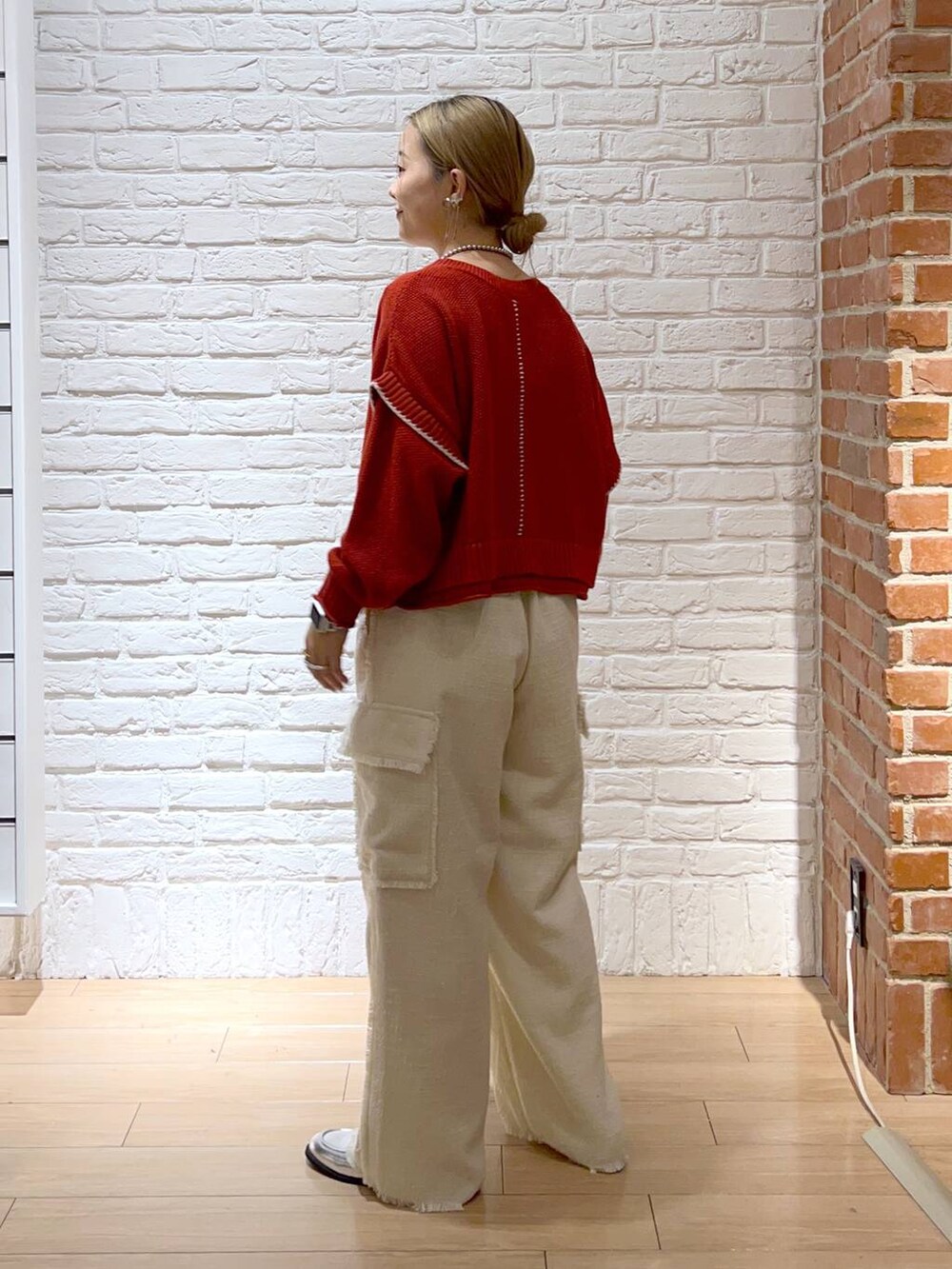 レッド系のニット/セーター、シルバー系のローファー、ホワイト系のその他パンツを着用したレディースの秋コーディネートの4枚目の写真