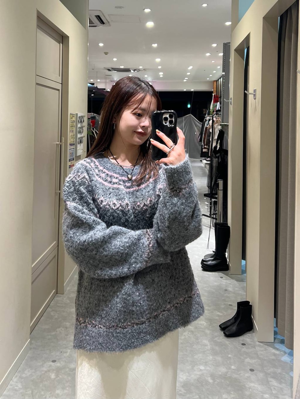 ホワイト系のスカート、グレー系のニット/セーターを着用したレディースの冬コーディネートの2枚目の写真