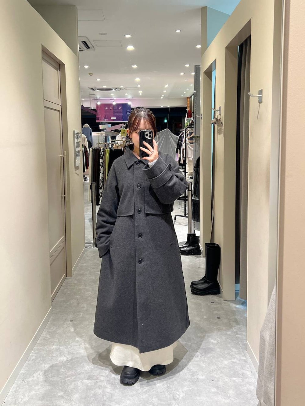 グレー系のステンカラーコート、グレー系のカーディガン/ボレロを着用したレディースの冬コーディネートの2枚目の写真