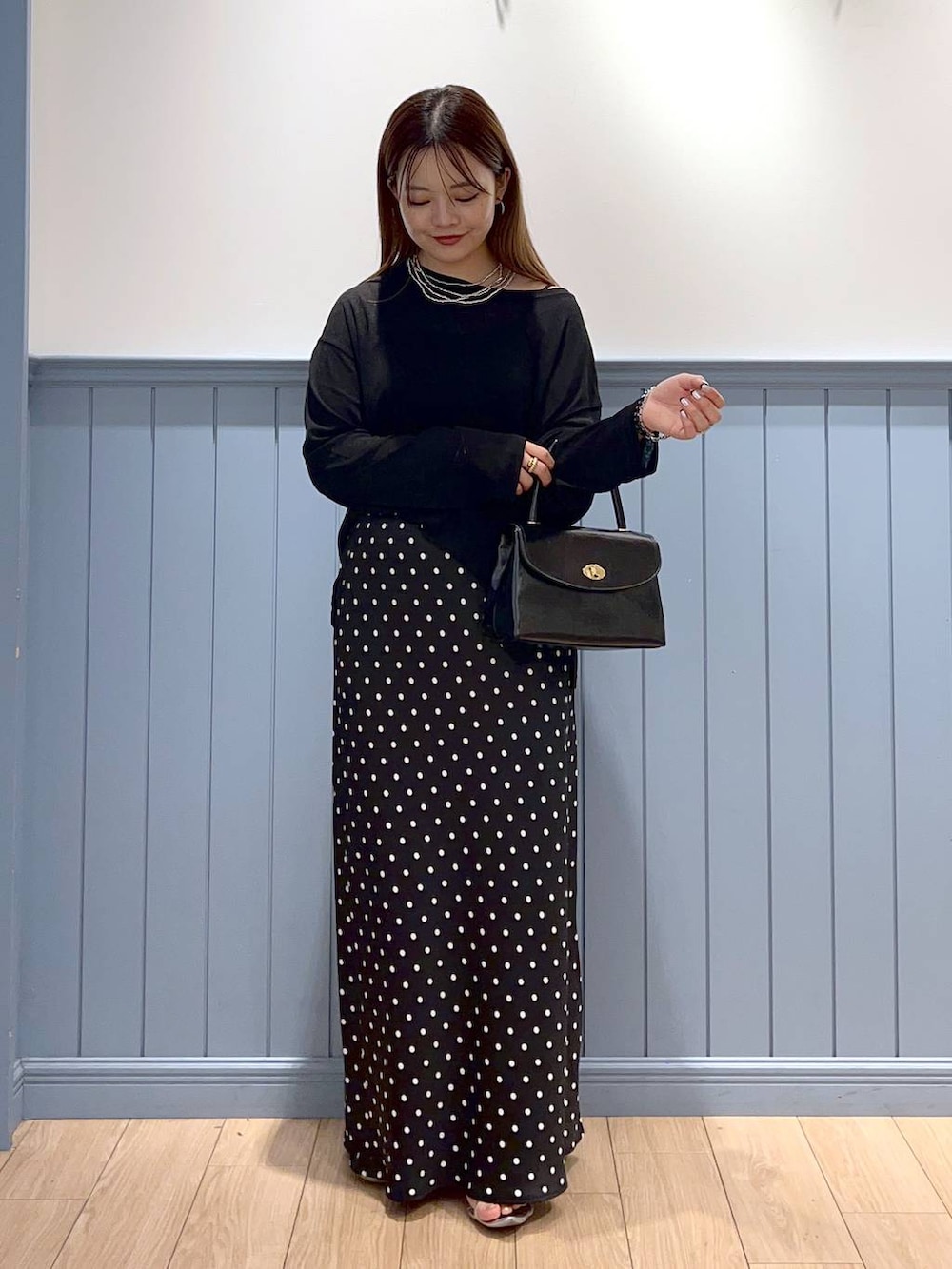 シルバー系のサンダル、ブラック系のスカート、ブラック系のTシャツ/カットソーを着用したレディースの秋コーディネートの2枚目の写真