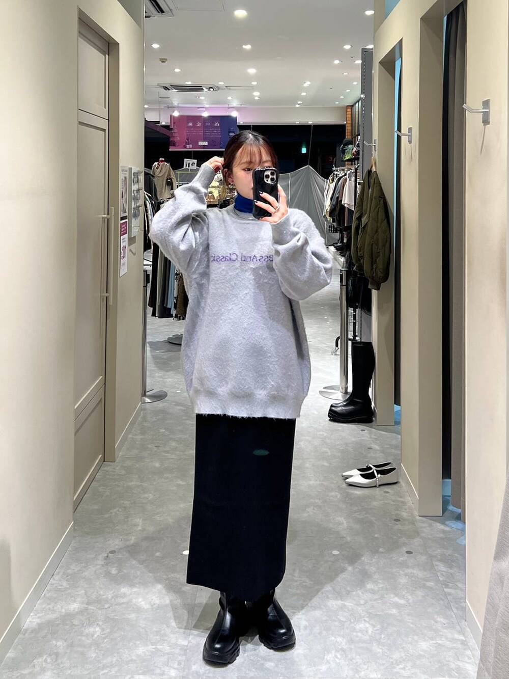 ブルー系のニット/セーター、ブラック系のスカート、グレー系のニット/セーターを着用したレディースの秋コーディネートの2枚目の写真