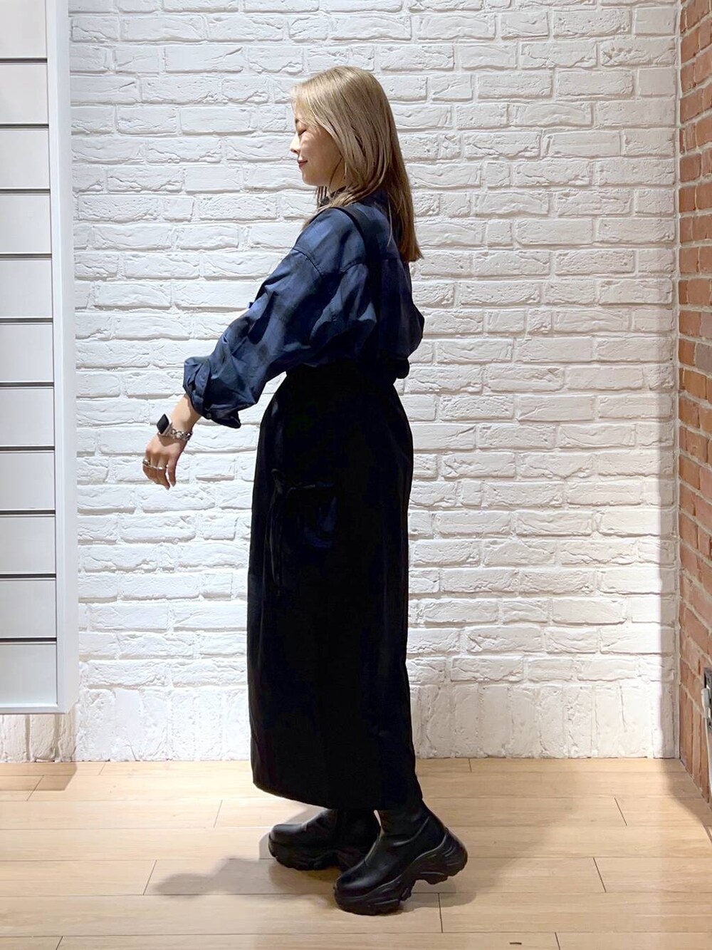 ブラック系のブーツ、ブルー系のシャツ/ブラウス、ブラック系のスカートを着用したレディースの秋コーディネートの3枚目の写真