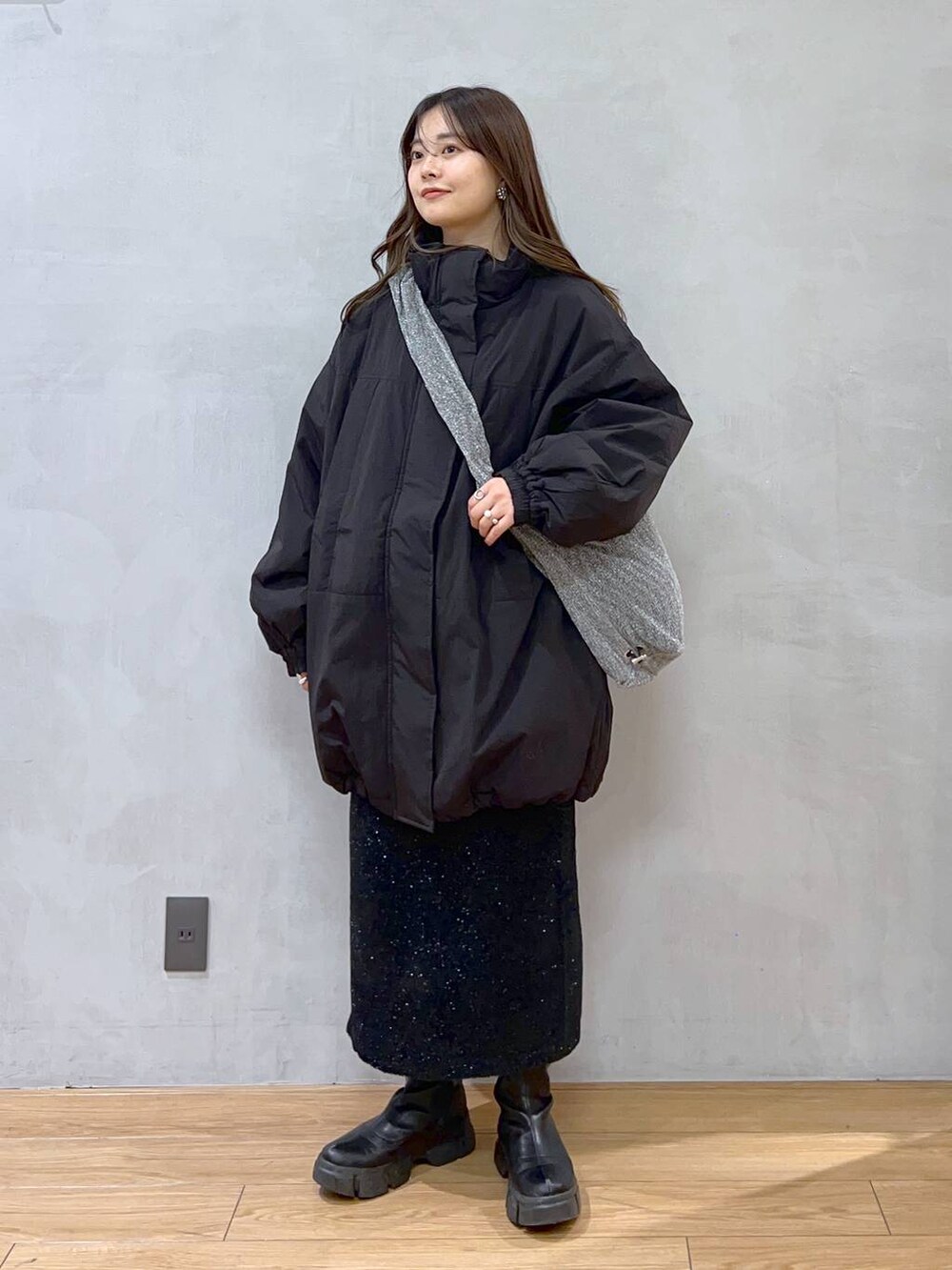 ブラック系のダウンジャケット/コート、シルバー系のショルダーバッグ、ブラック系のブーツを着用したレディースの秋コーディネートの3枚目の写真